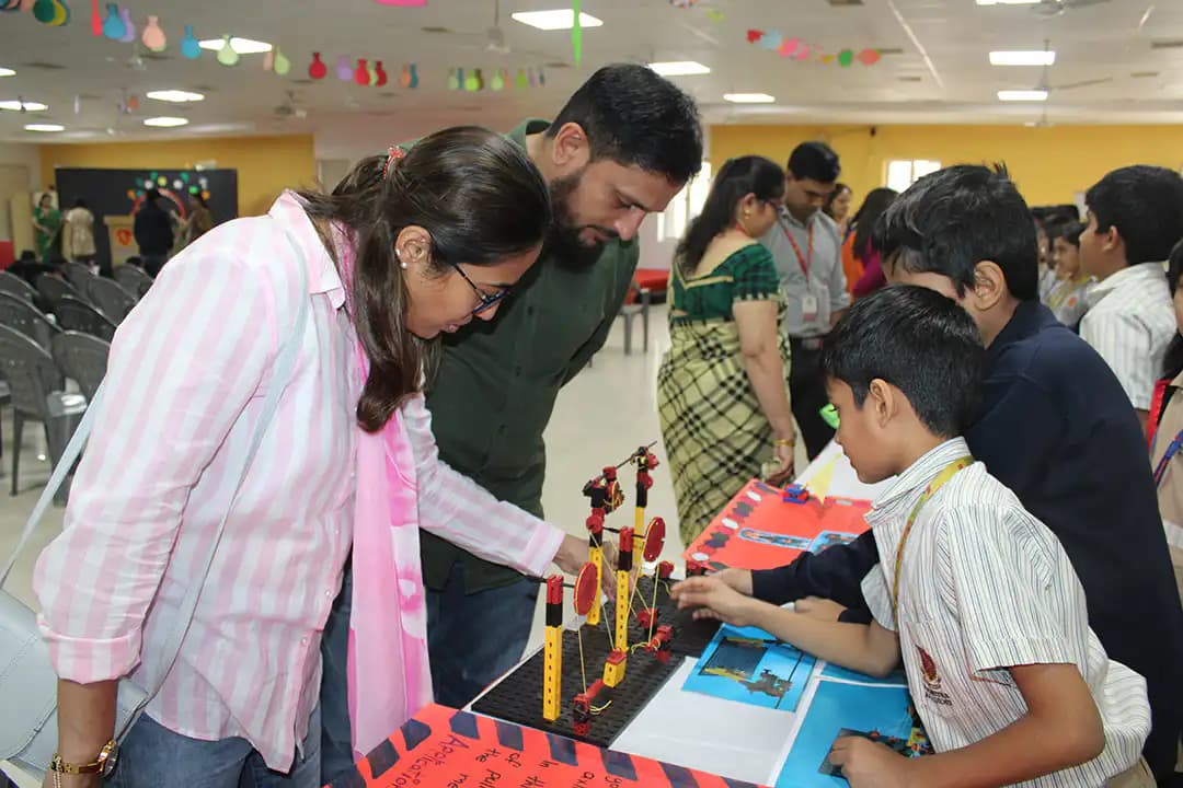 Student explaining a working model to visitors at Suchitra's makerspace exhibition