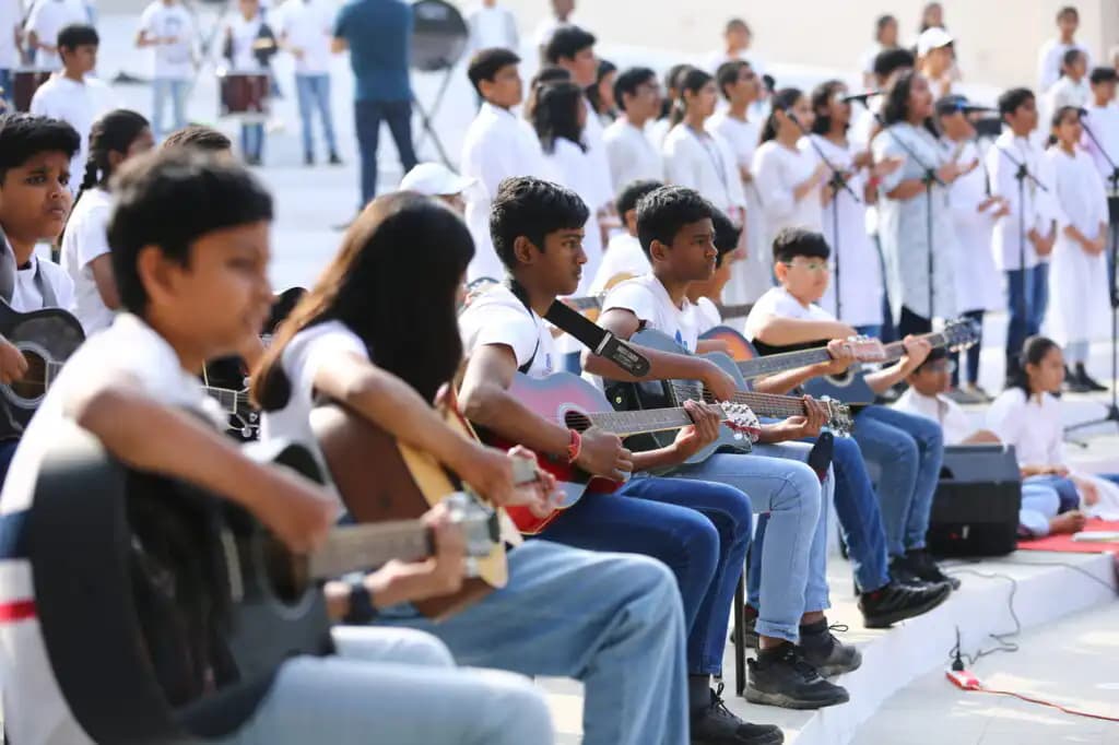 Suchitra pupils playing guitars at an outdoor school performance