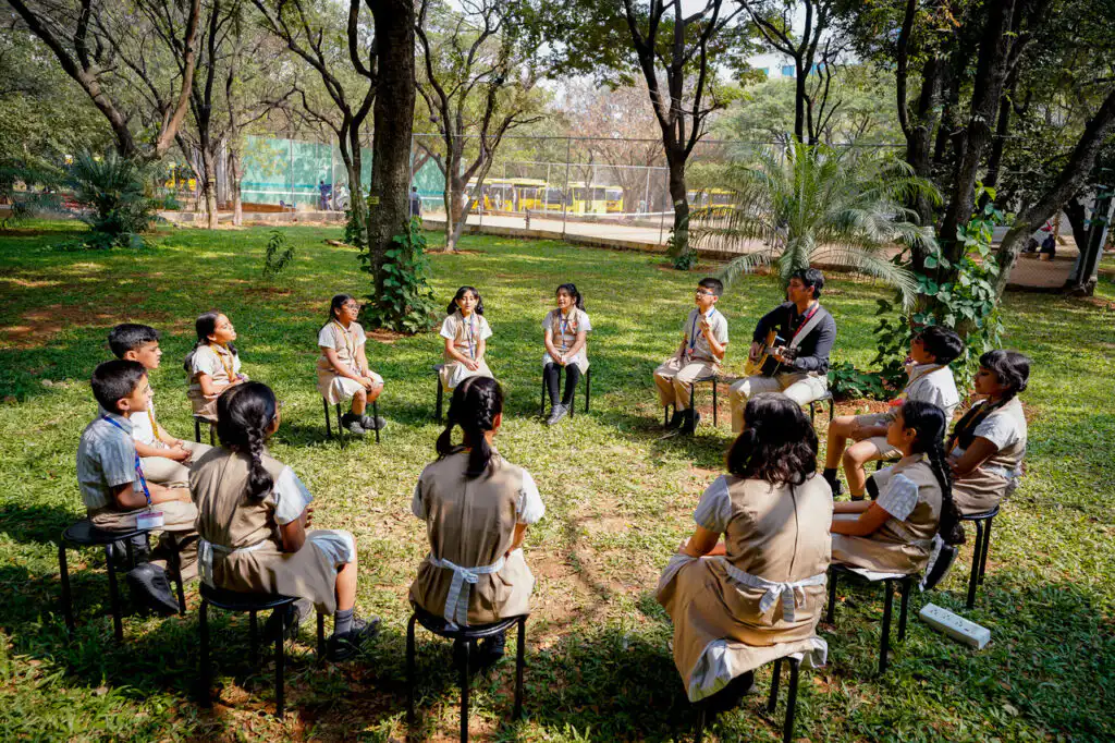 Students and a teacher learning together outdoors on Suchitra's campus